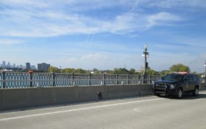 A Michigan Department of Natural Resources patrol vehicle is shown parked on the MacArthur Bridge Saturday. A ResQ Disc sits on the bridge rail. A 49-year-old Detroit man was saved from a suicide attempt by a DNR conservation officer and Detroit Police Department officer. PHOTO CREDIT: Michigan Department of Natural Resources